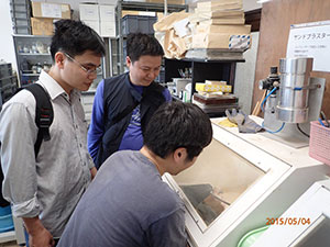 化石クリーニング室でサンドブラスターを用いたベトナム産アンモナイト化石の剖出作業を見学している様子