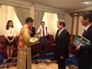 画像：程大使に持参したお土産を手渡す生徒代表。右端は阮湘平公使参事官