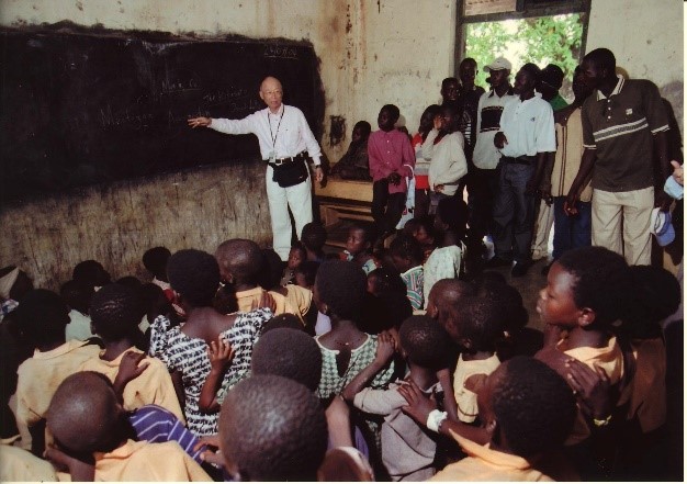 Omura speaking to children in Africa